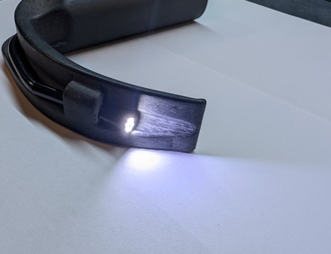 Spatelspitze mit eingesetzter Kamera, deren LED Beleuchtung das Papier darunter hell anstrahlt