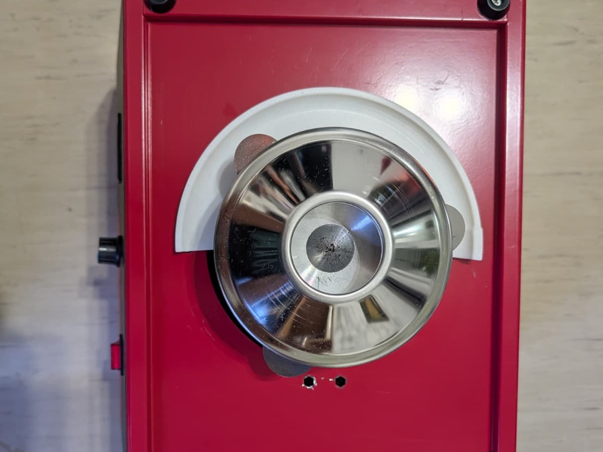 Zuckerwattemaschine von oben, auf einer Seite des Drehtellers liegt eine weiße Ringhälfte
